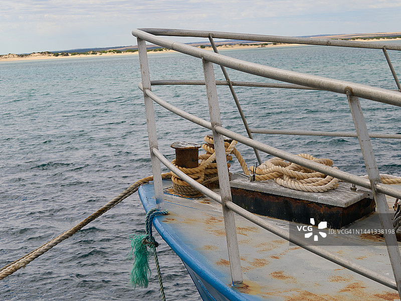 系泊在码头的船头，金属甲板和系在系缆柱上的绳索，金属栏杆图片素材