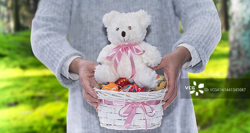 坐在复活节彩蛋篮子上的泰迪熊图片素材