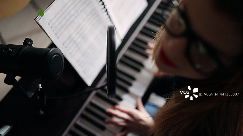 模糊的女人唱歌和弹电子琴的俯视图图片素材