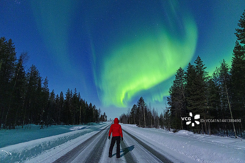 男人站在雪地上观看北极光图片素材