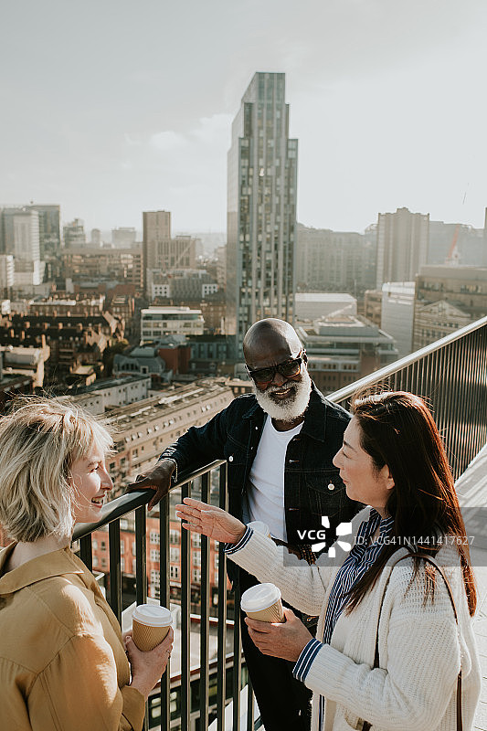 站在城市屋顶/阳台上的三个人图片素材