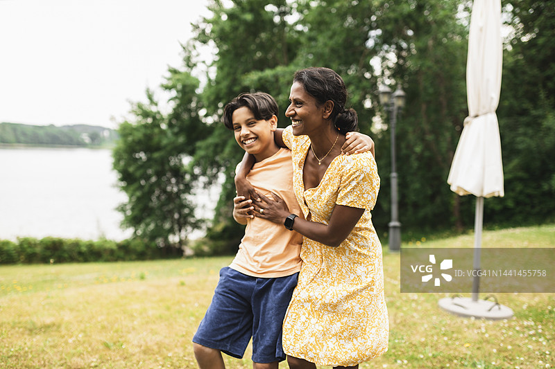 快乐的女人在后院搂着儿子享受时光图片素材