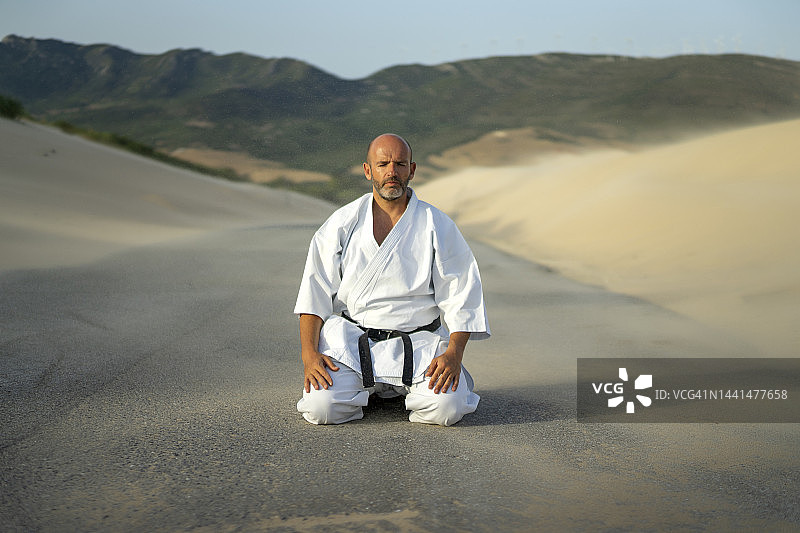 身穿空手道服和黑带练习空手道的健壮男人图片素材