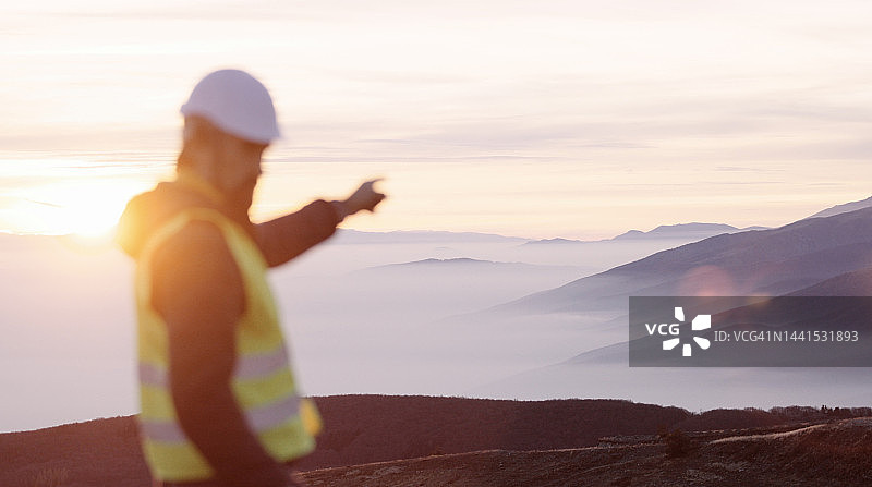 在风力发电场工作的风能工程师：可再生能源系统，碳中和与可持续能源图片素材