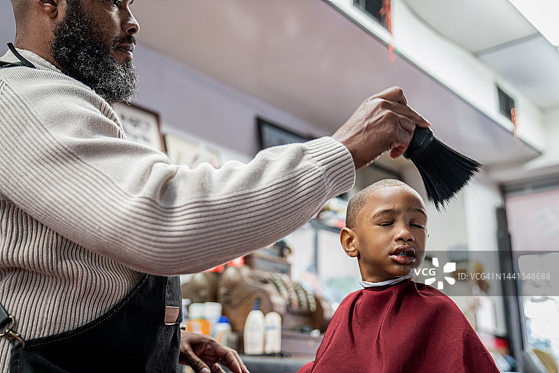 在黑人理发店里，黑人顾客正在理发图片素材