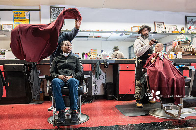 在黑人理发店里，黑人顾客正在理发图片素材