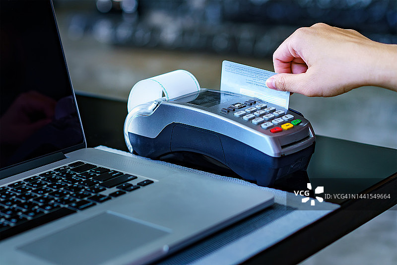 顾客在信用卡读卡器上使用信用卡付款的裁剪图像图片素材