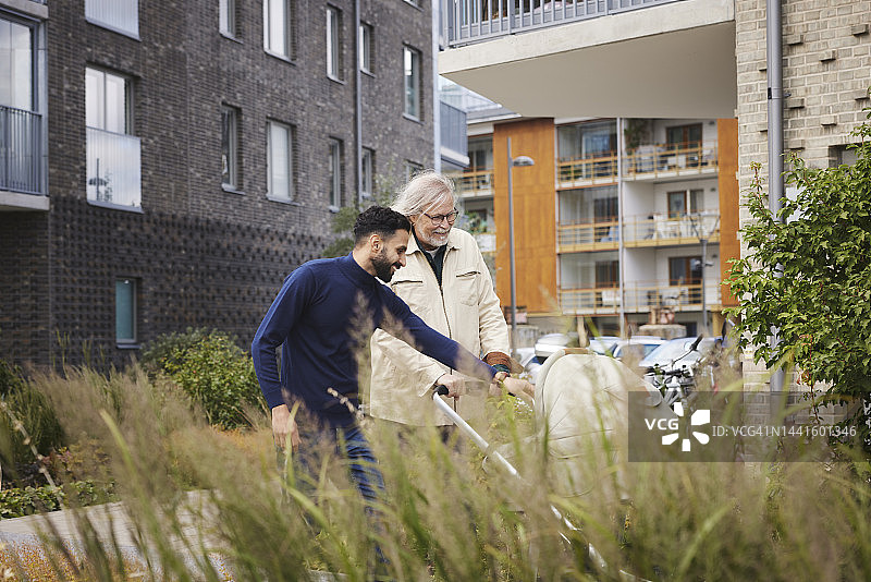 在公寓楼前交谈的男人们图片素材
