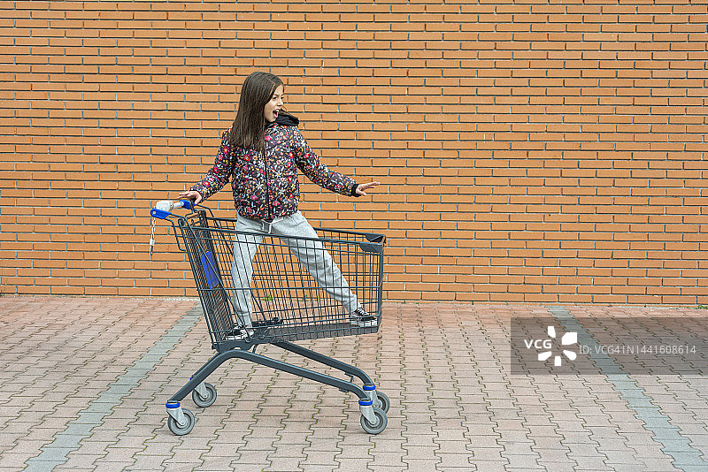 小女孩坐在购物车里图片素材