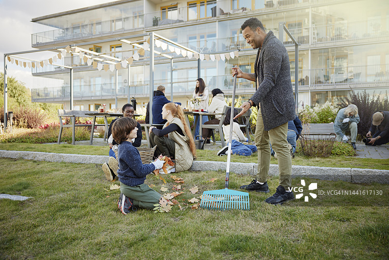 邻居们在公共户外区域放松并清理落叶图片素材