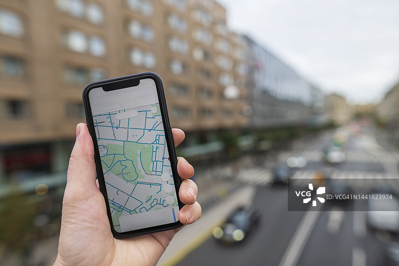手持智能手机，屏幕显示地图应用程序图片素材