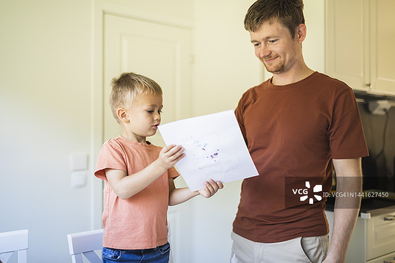 儿子在家给父亲看画图片素材