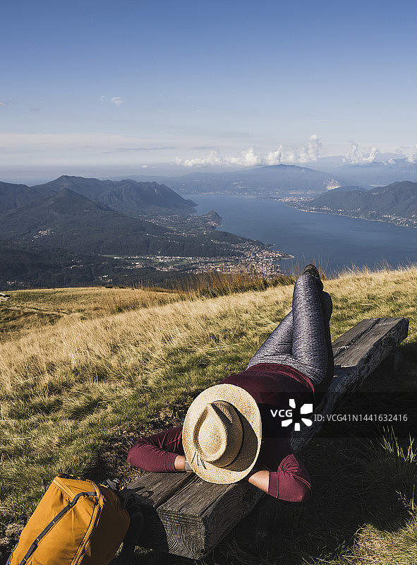 中年妇女戴着帽子在长椅上放松图片素材