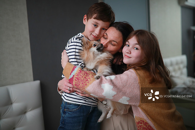 自信的中产阶级妇女在家与孩子和狗在一起图片素材