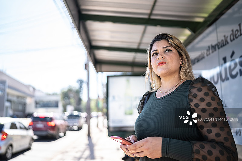 在巴士站等候的中年妇女图片素材