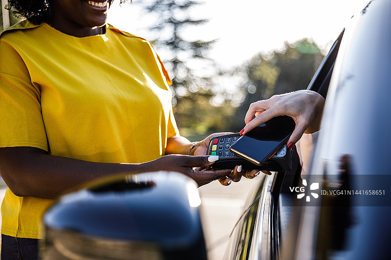 服务人员通过智能手机收取路边客户的付款图片素材