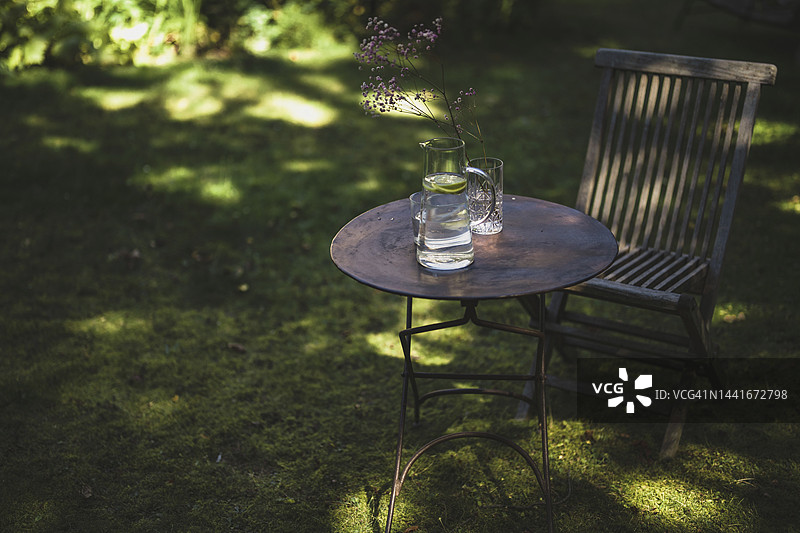 花园里的桌子和椅子上放着一个水壶图片素材