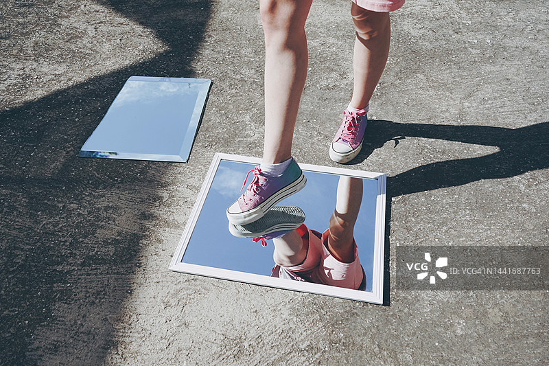 穿着帆布鞋的女人踩在镜子上图片素材