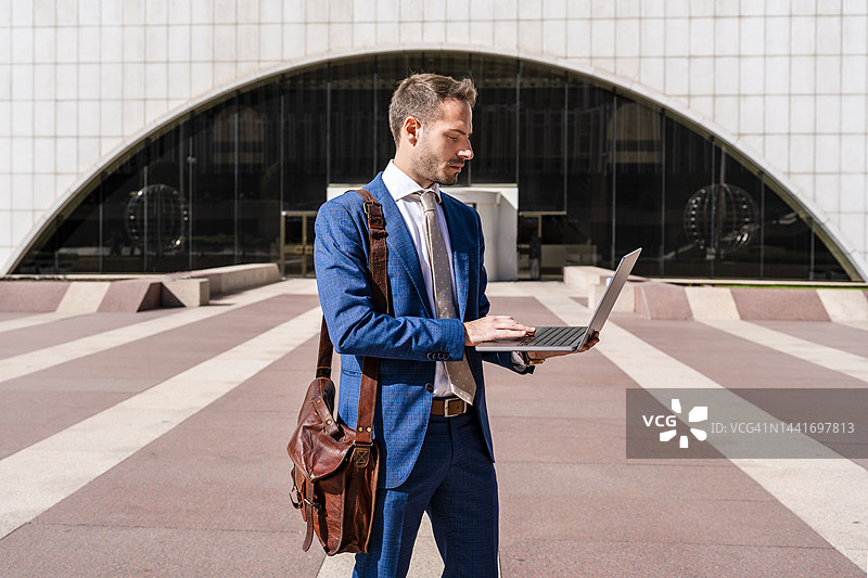 商人在办公园区使用笔记本电脑工作图片素材