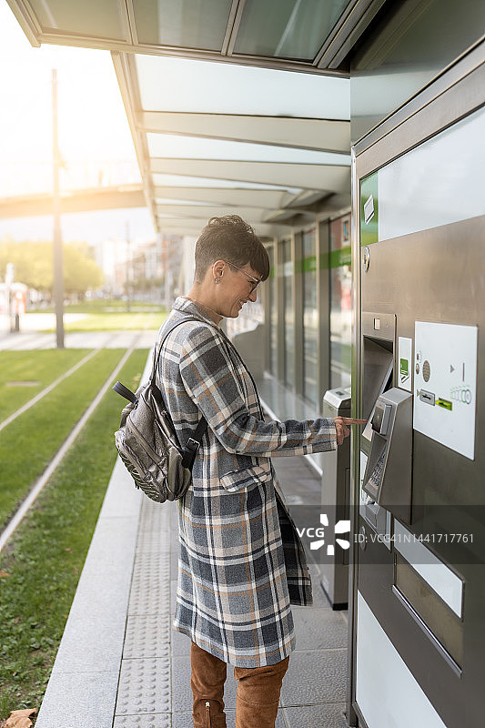 女人在城市公共交通上取电车票图片素材