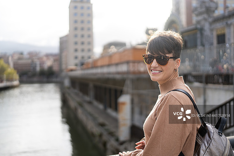 在城市中行走微笑的女人图片素材