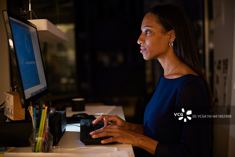 在光线昏暗的办公室里工作到深夜的优雅黑人商人肖像图片素材