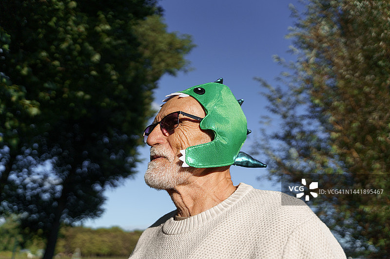 戴着恐龙面具的老人肖像图片素材