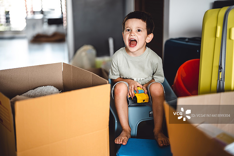 搬家时坐在椅子上哭喊的小男孩图片素材
