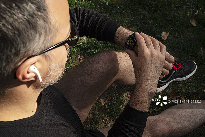 中年男人设置跑步智能手表特写图片素材