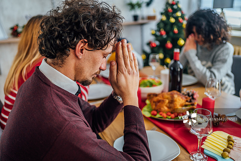 男子在圣诞午餐前祈祷图片素材