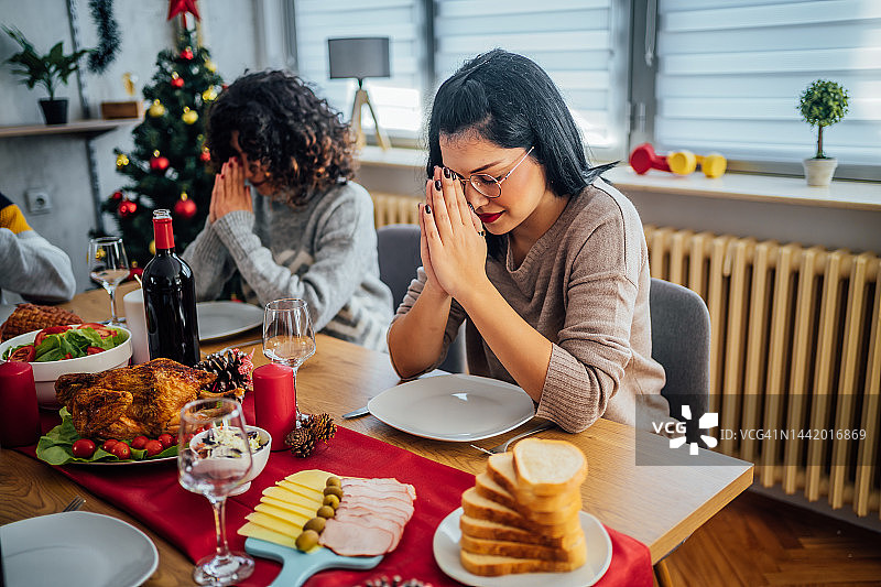 在圣诞午餐前祈祷的女人图片素材
