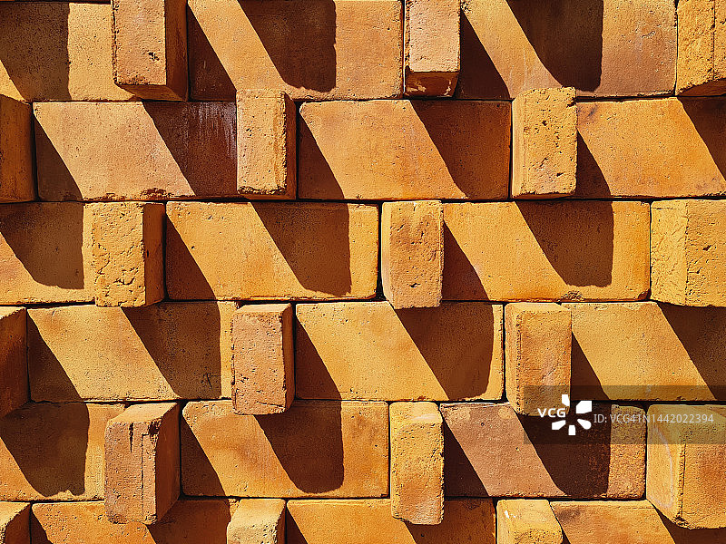 阳光和阴影之间的红砖墙纹理图片素材