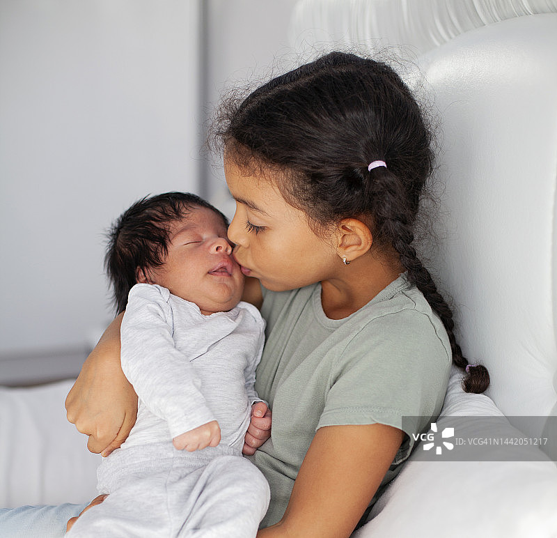 非洲裔姐姐在床上拥抱弟弟图片素材