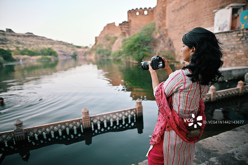 中年女游客在拉贾斯坦邦焦特布尔湖边拍照图片素材