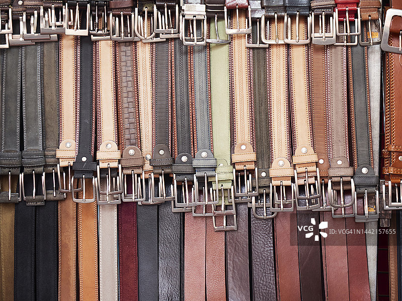 市场摊位上悬挂的皮革腰带图片素材