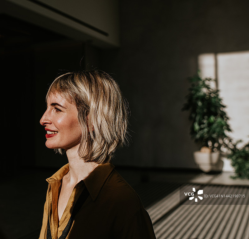 阳光照耀下，戴着鼻环，笼罩在阴影中的年轻美女肖像图片素材