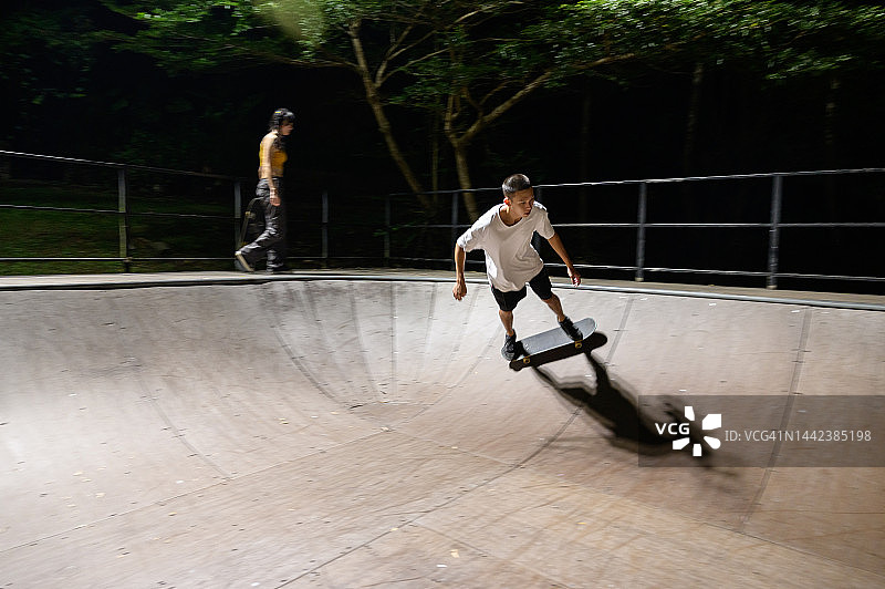 在滑板公园玩滑板的年轻男人图片素材