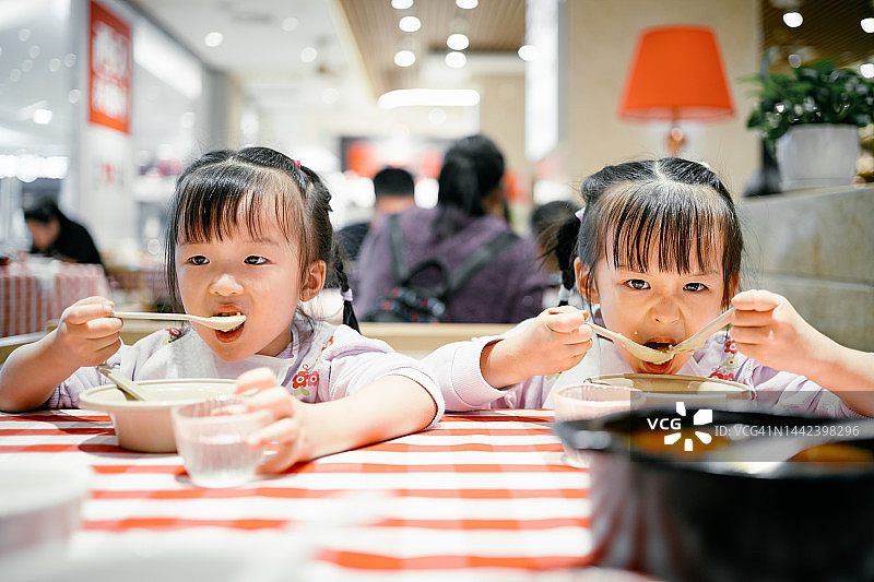 两名亚洲4岁女孩在餐厅里渴望食物图片素材
