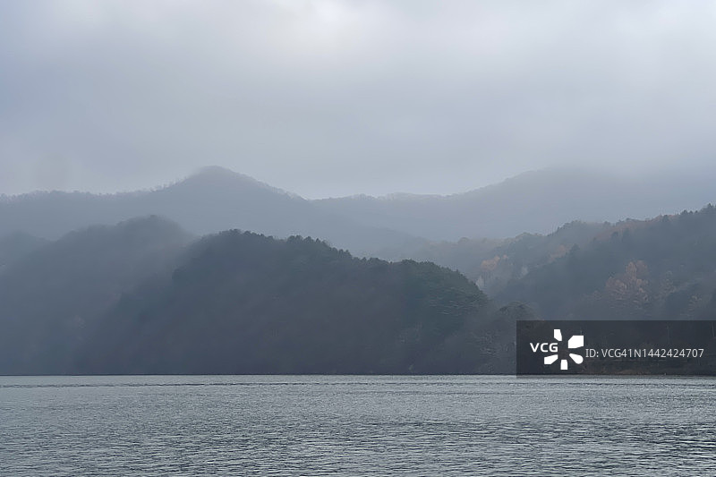 韩国南怡岛：清平水坝的阴天秋景，山脉轮廓和湖泊的朦胧气氛图片素材
