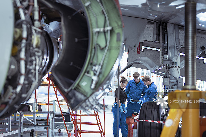大型飞机下的飞机维修学徒工程师团队图片素材