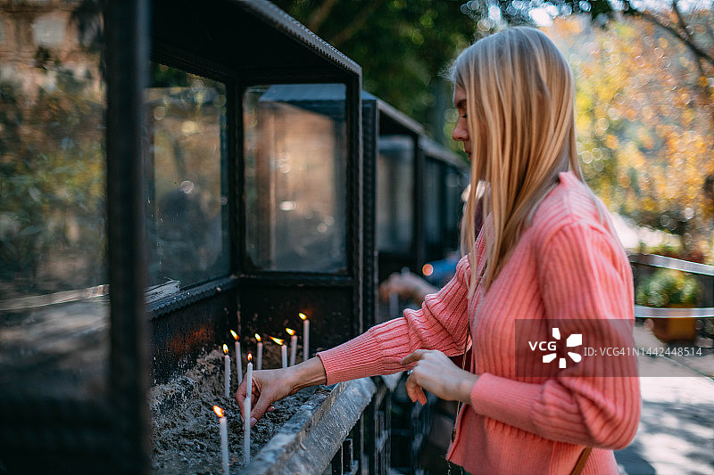 手持教堂蜡烛祈祷的女人图片素材
