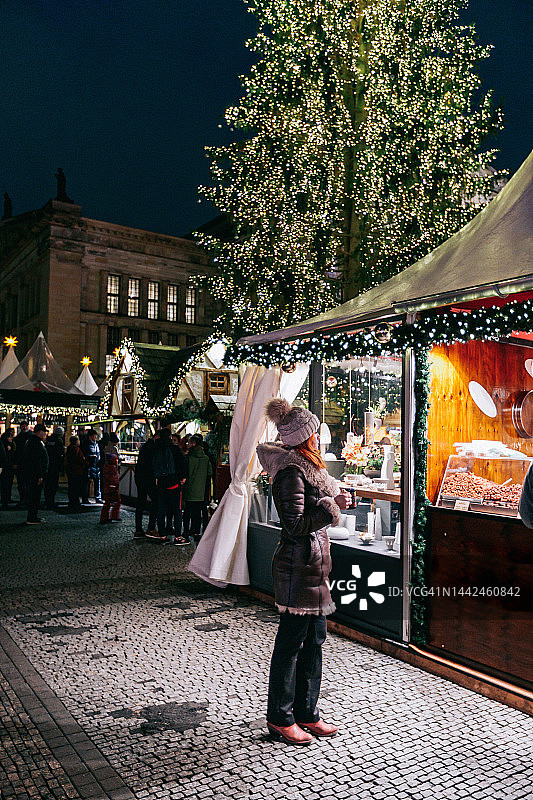 在圣诞市场摊位上穿着暖和衣服的女人图片素材