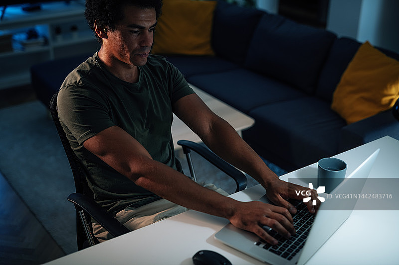 在家工作的中年男人使用数码设备与同事进行视频通话图片素材