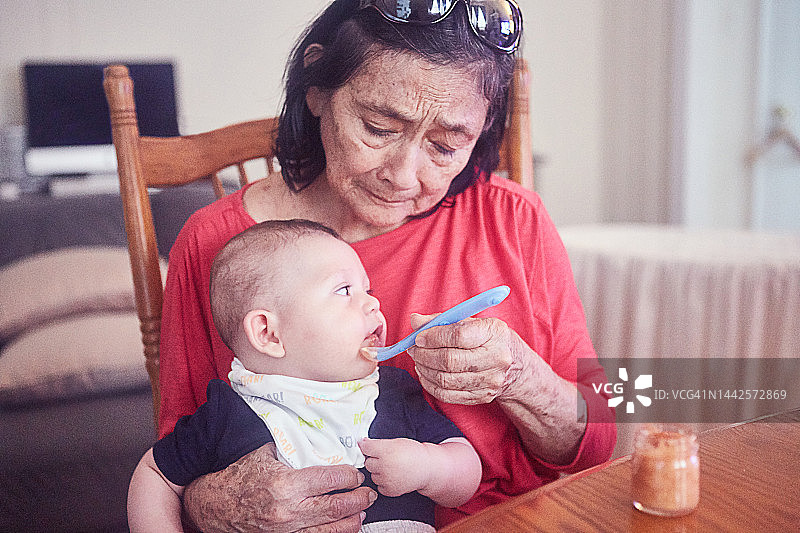 祖母给孙子喂饭图片素材