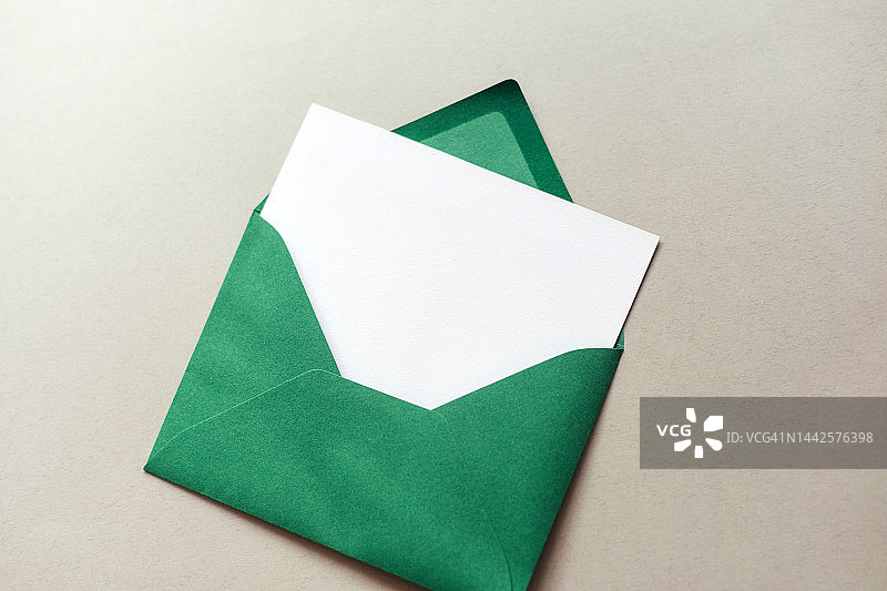 灰色背景上的绿色信封和白色纸张：新年圣诞愿望清单图片素材