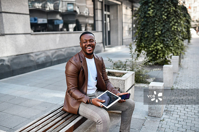 微笑的优雅非洲银行家使用平板电脑查看账户图片素材