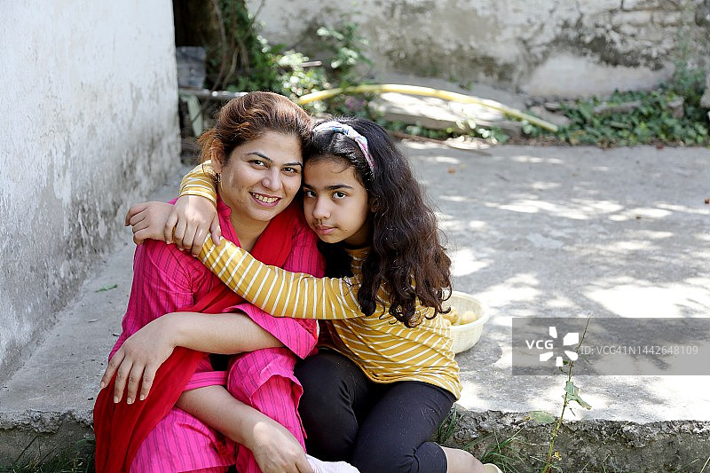 女儿拥抱母亲，看着镜头图片素材