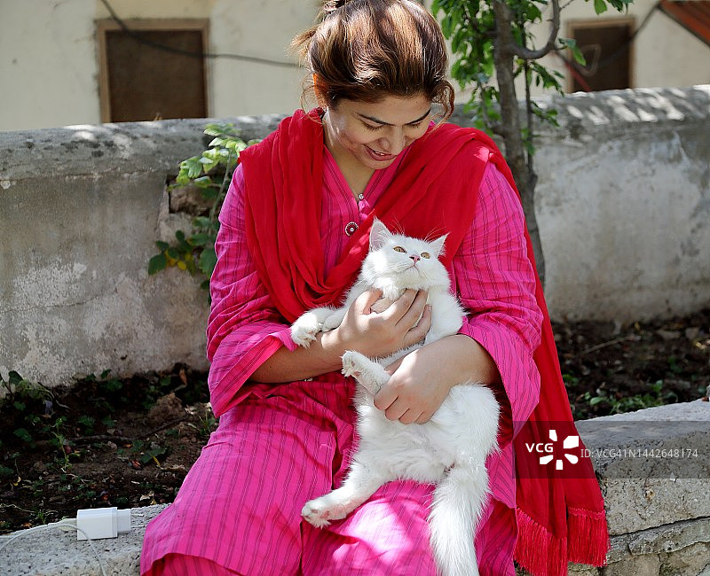 怀抱宠物猫，享受欢乐时光的女人图片素材