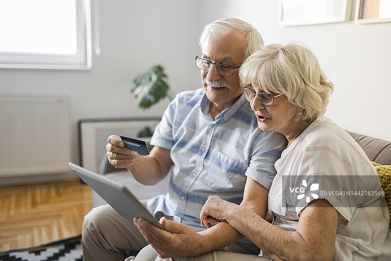 年长夫妇使用信用卡在网上购物图片素材