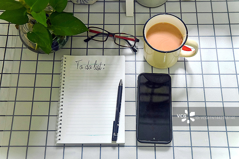 带笔的待办事项清单记事本在桌子上图片素材